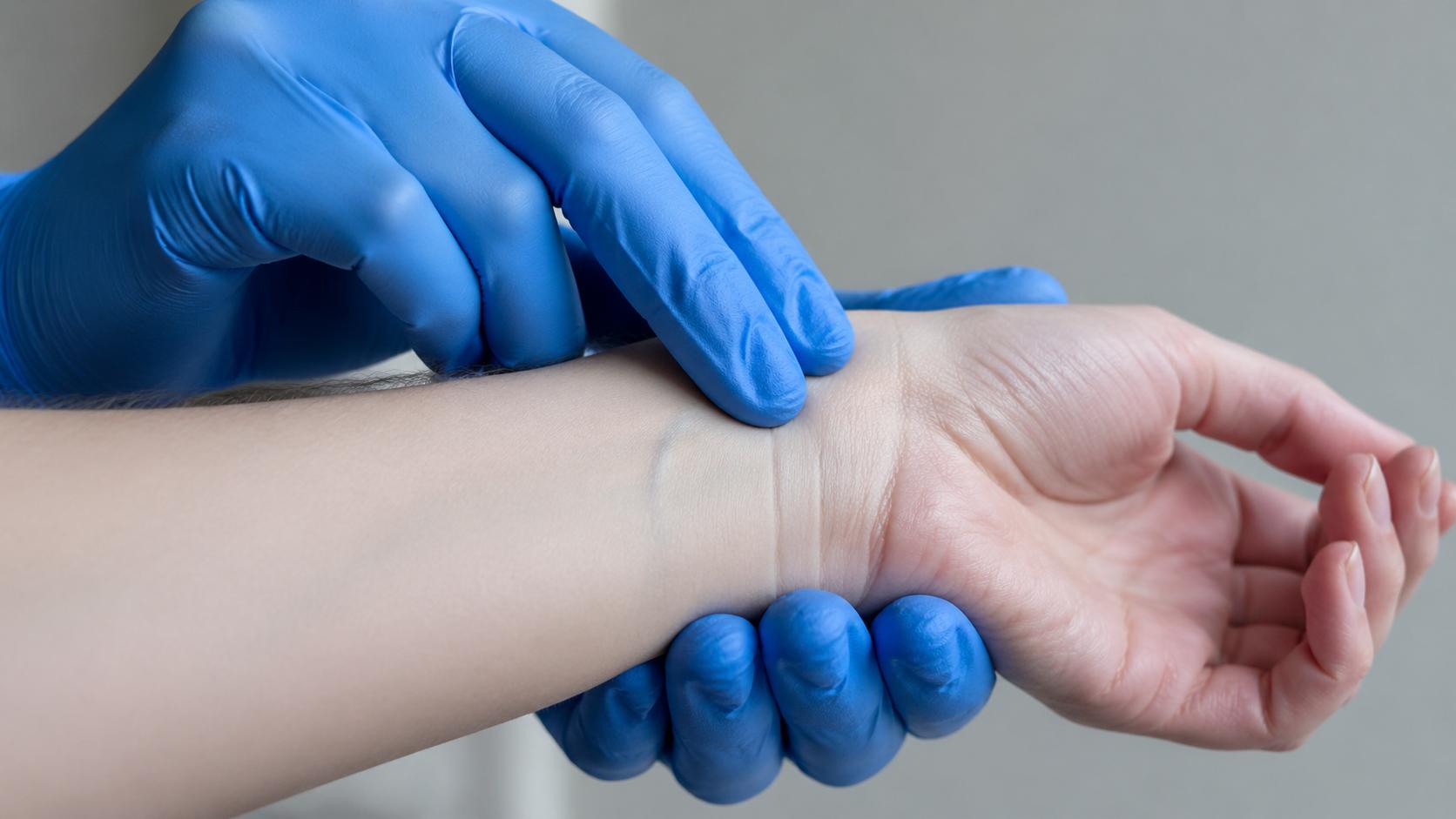 Close-up of a responder in nitrile gloves gently holding a patient's pale wrist and checking for a radial pulse, soft diffused natural lighting, empathetic documentary photography