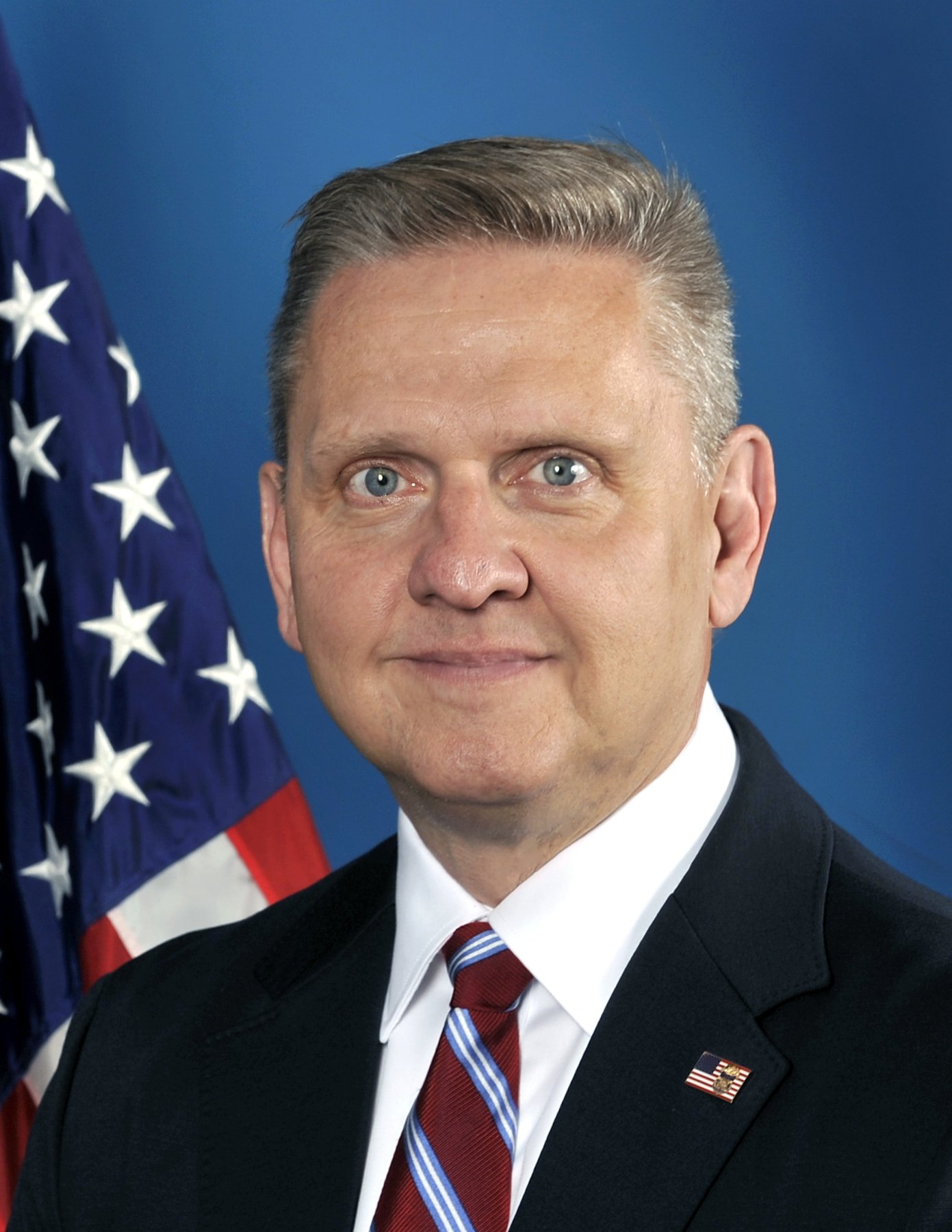 Official portrait of Robert Cekada of the Bureau of Alcohol, Tobacco, Firearms and Explosives in front of an American flag