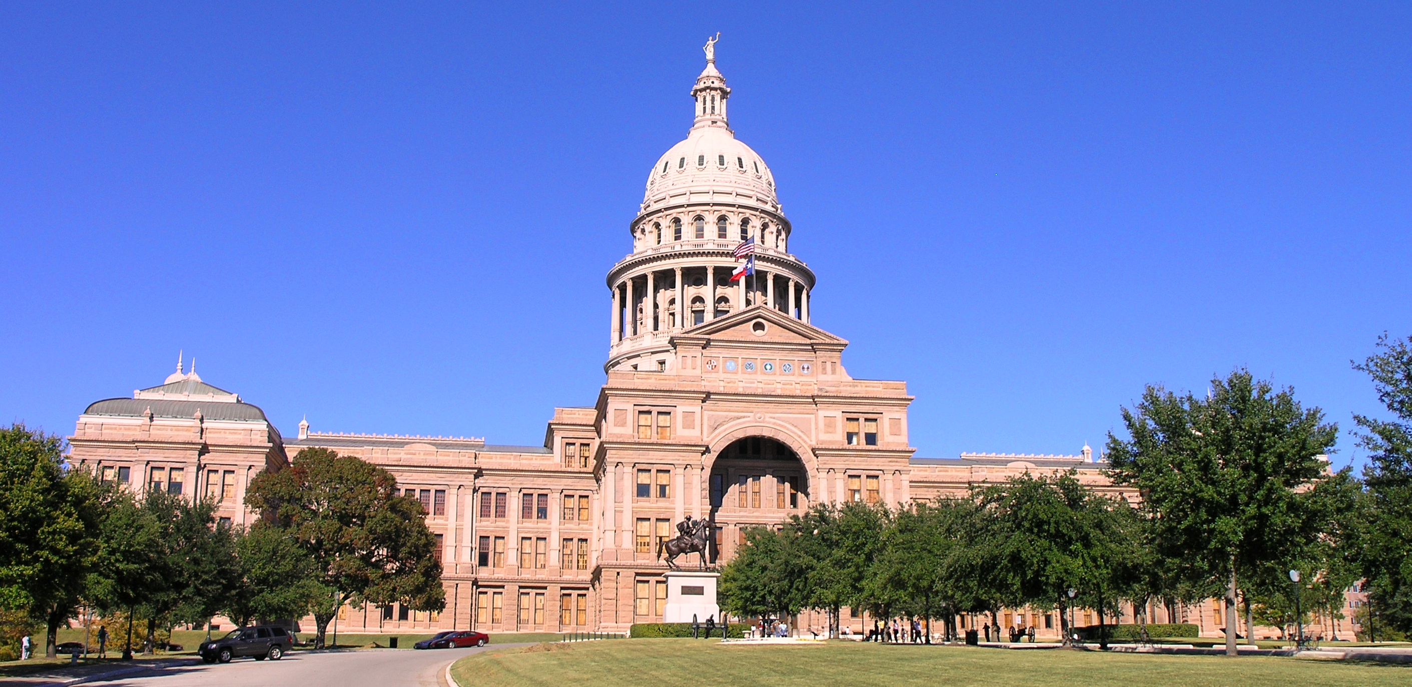 The Texas State Capitol building in downtown Austin under a clear blue sky