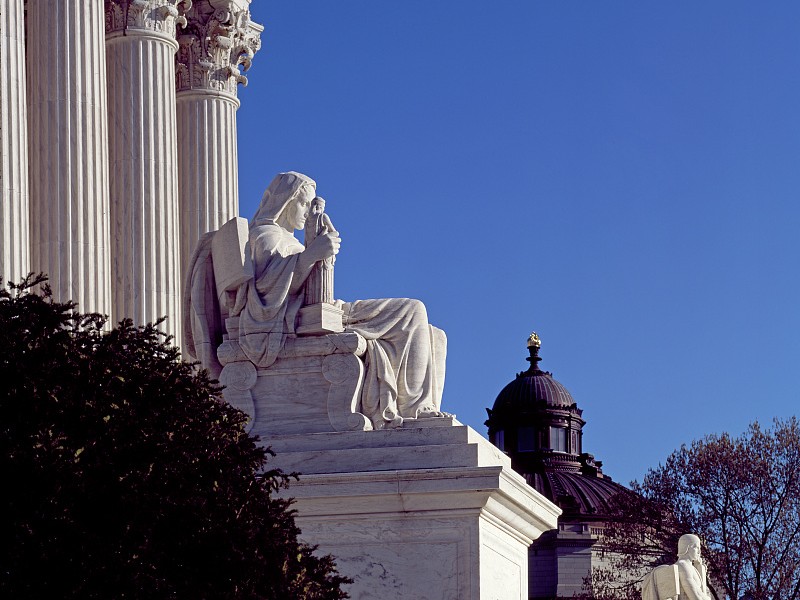 Marble columns and a seated statue outside the U.S. Supreme Court building in Washington, D.C.