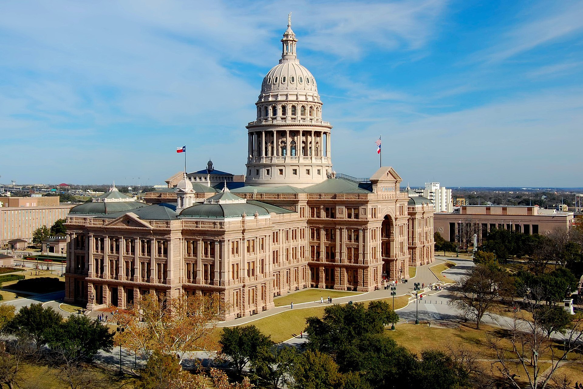 Aerial view of the Texas State Capitol in Austin with the Texas flag flying