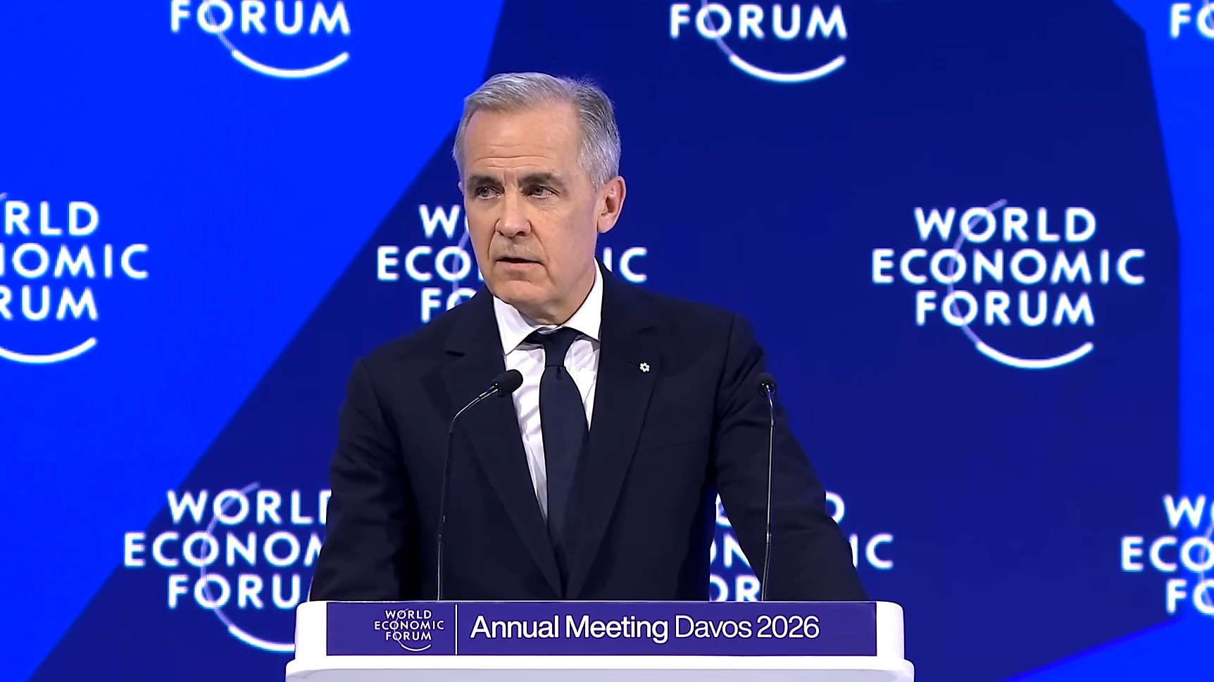 Canadian Prime Minister Mark Carney speaking at a podium at the World Economic Forum in Davos