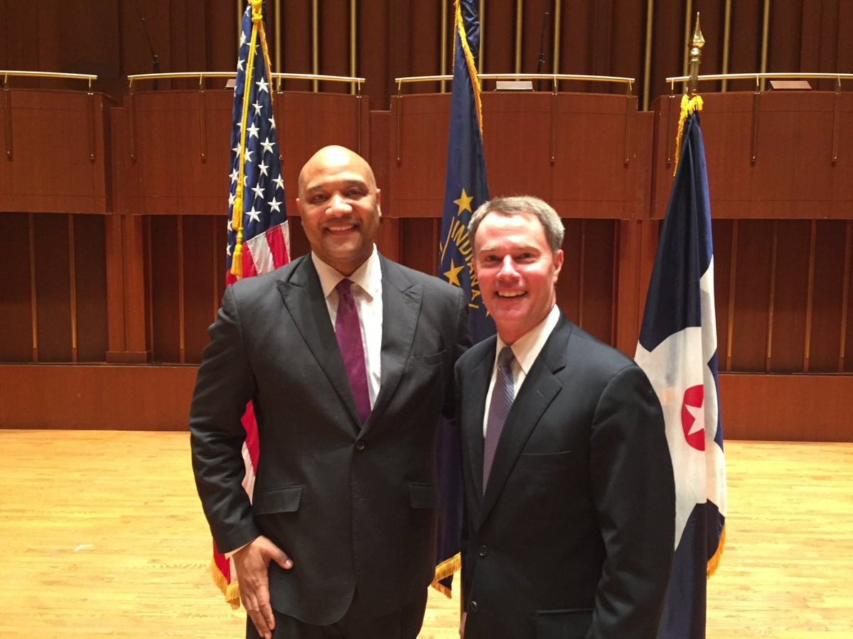 Rep. André Carson standing with Joe Hogsett in front of American, Indiana and Indianapolis flags in January 2016