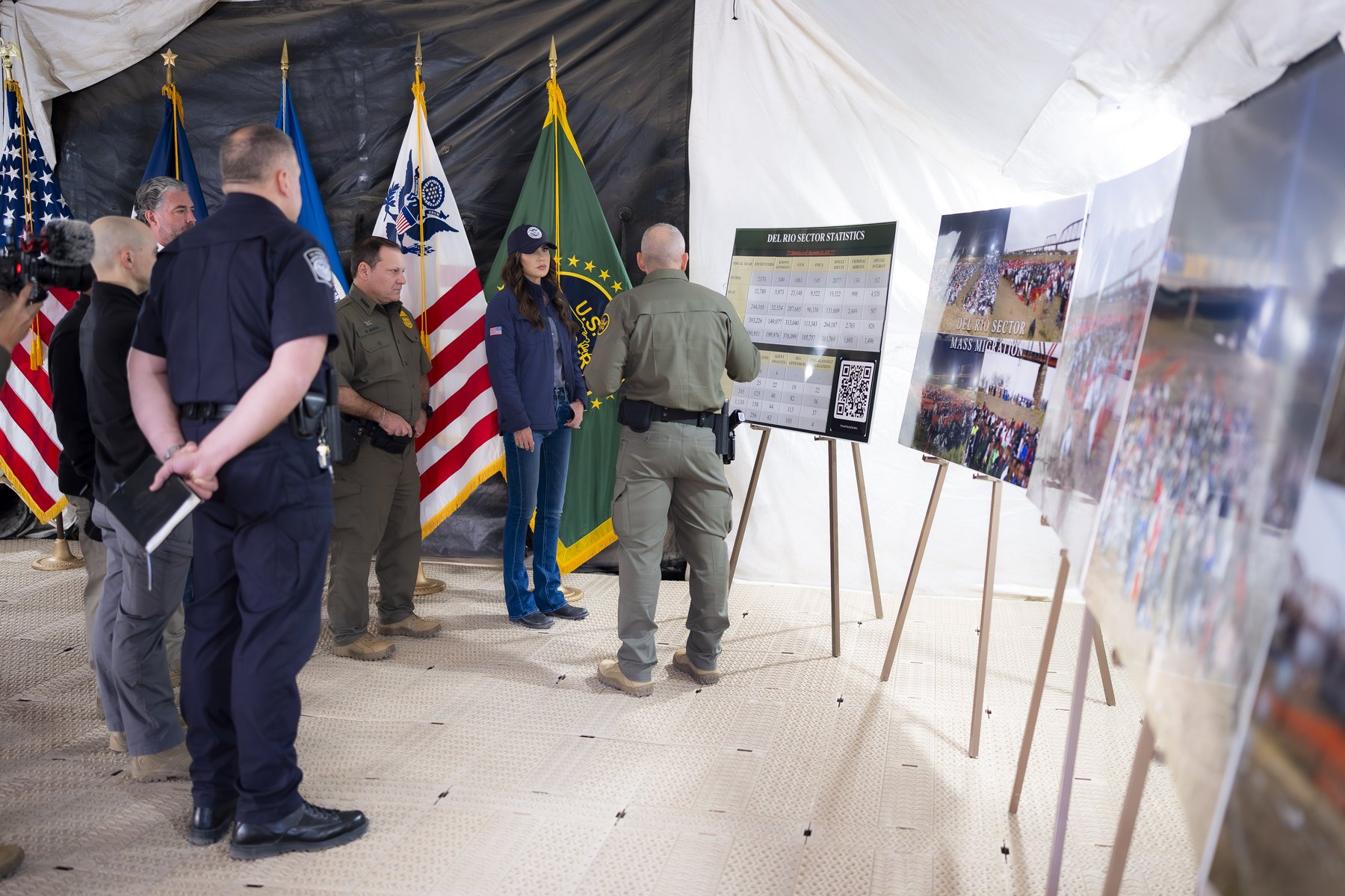 Border officials give a briefing at Shelby Park in Eagle Pass, Texas, in front of Del Rio Sector statistics and photos of past mass crossings
