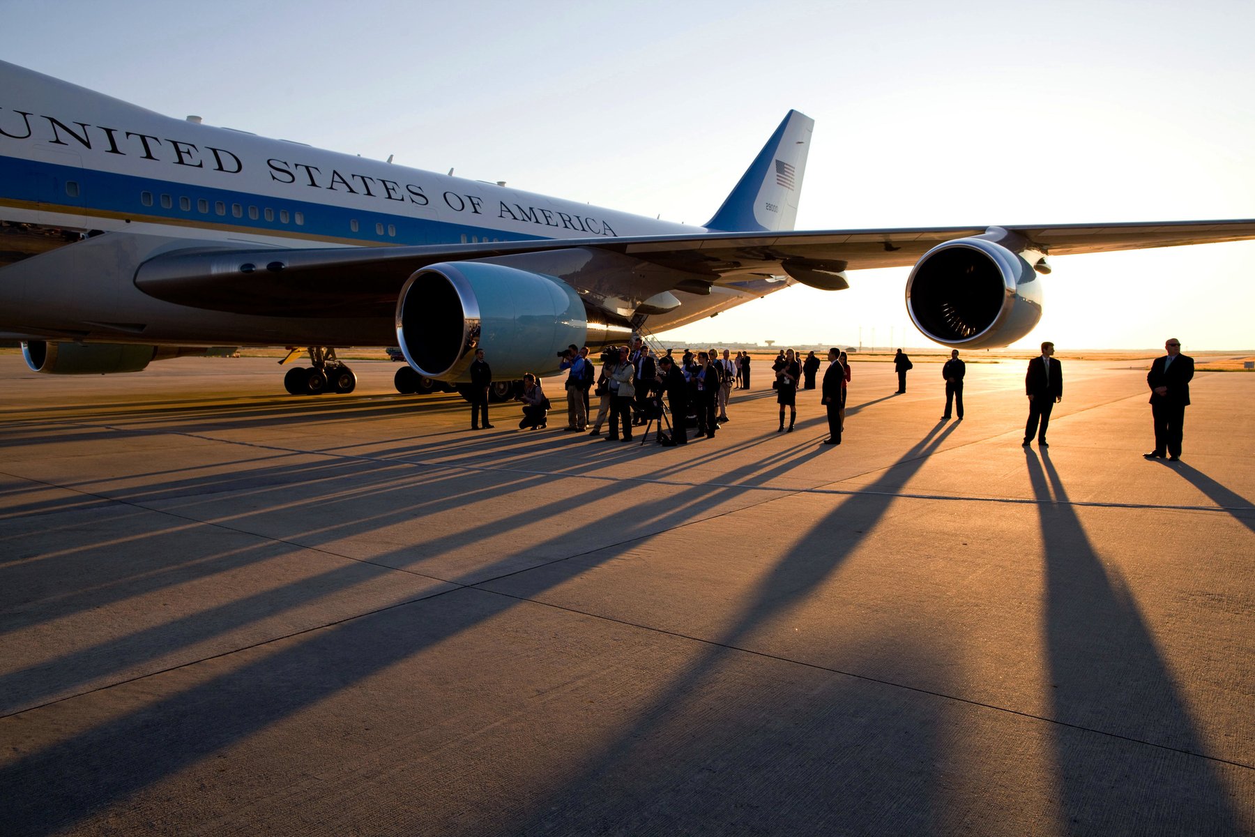 The White House press pool, with television cameras, gathered under the wing of Air Force One on an airport tarmac