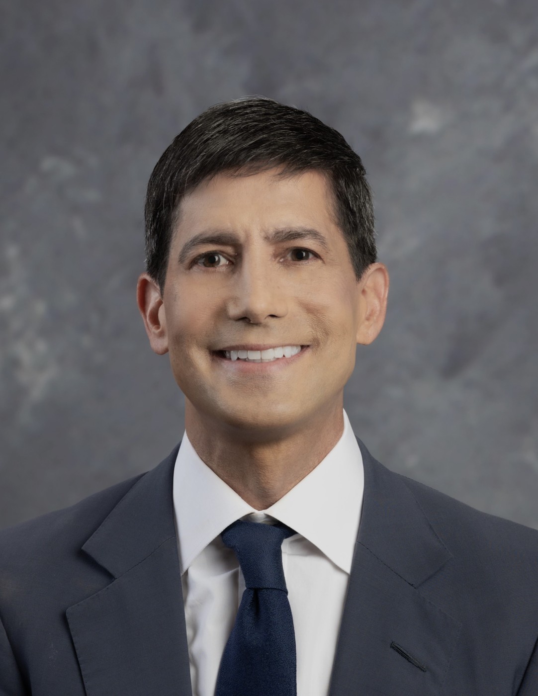 Official Federal Reserve Board portrait of Kevin Warsh in a gray suit and navy tie