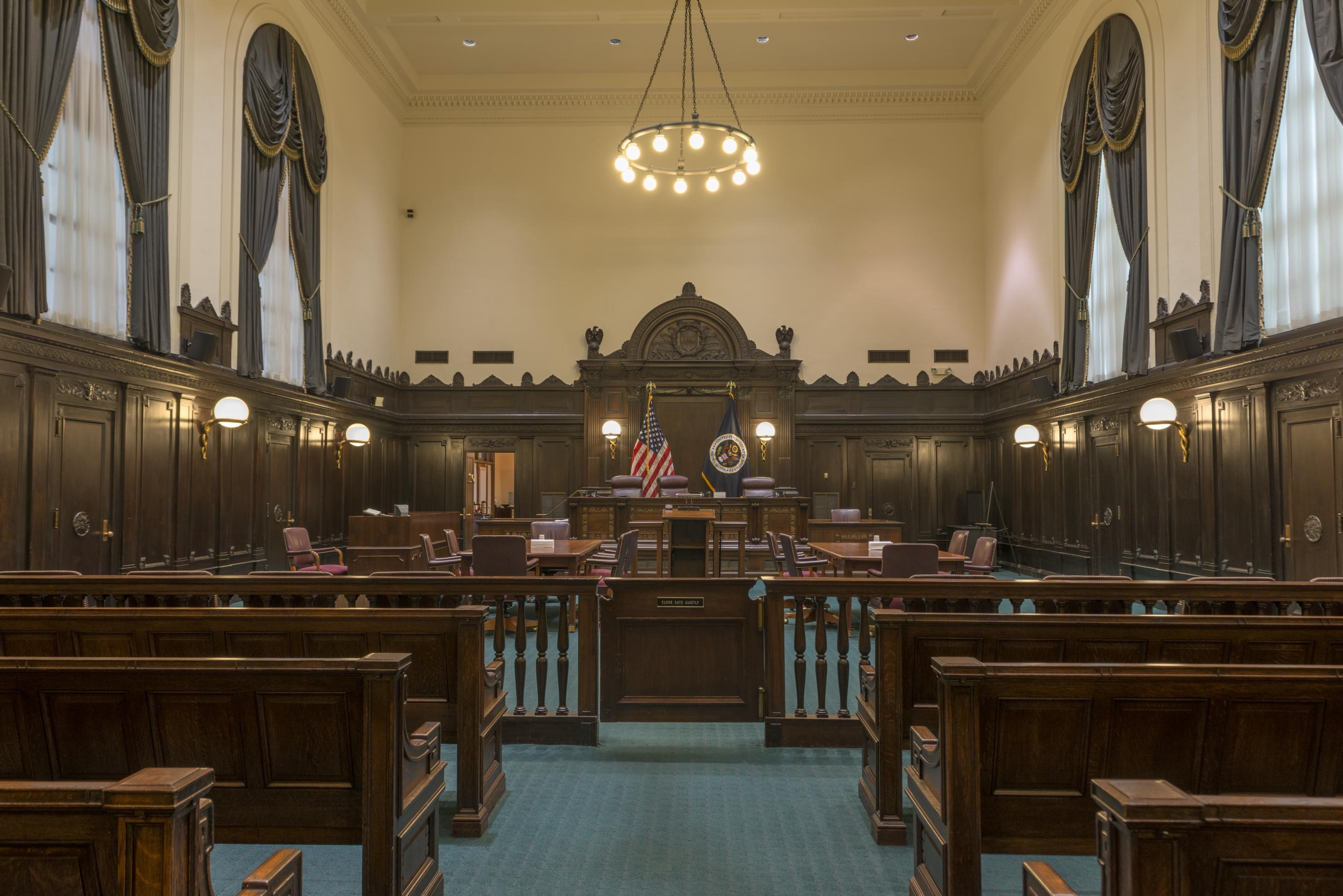 Empty courtroom in the John Minor Wisdom U.S. Court of Appeals Building in New Orleans, with judges' bench, flags and gallery benches