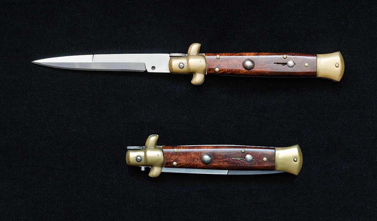 An Italian stiletto-style switchblade photographed open and closed on a black background