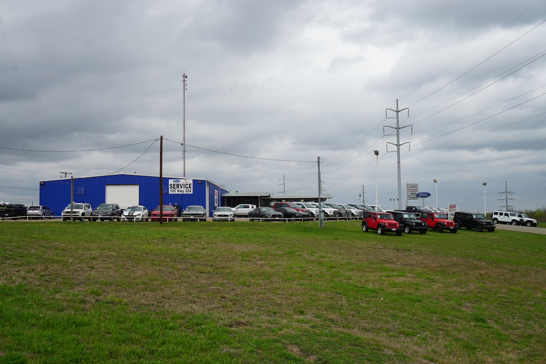 Jeeps and pickup trucks lined up on a dealership lot in Commerce, Texas