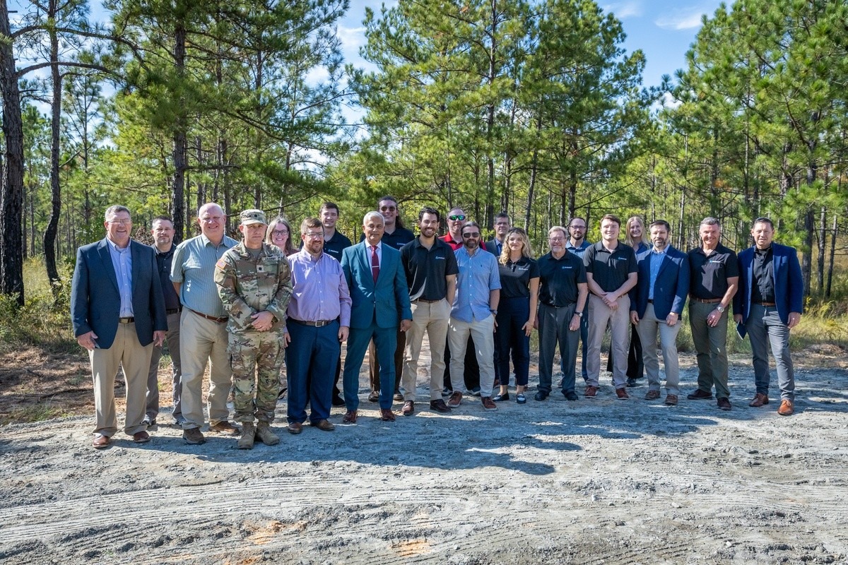 Fort Benning leaders, Army energy officials and Radiant Industries staff posing at a wooded site during the Oct. 16, 2026 Janus Program site visit