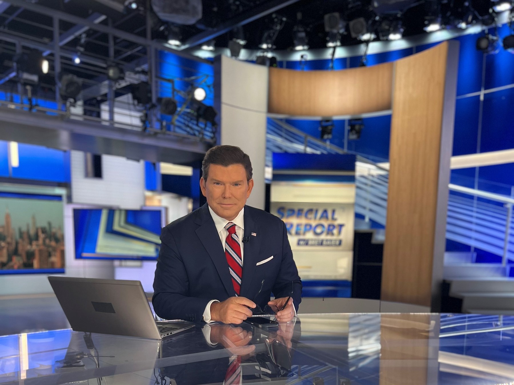 Bret Baier seated at the Special Report anchor desk in the Fox News studio in New York