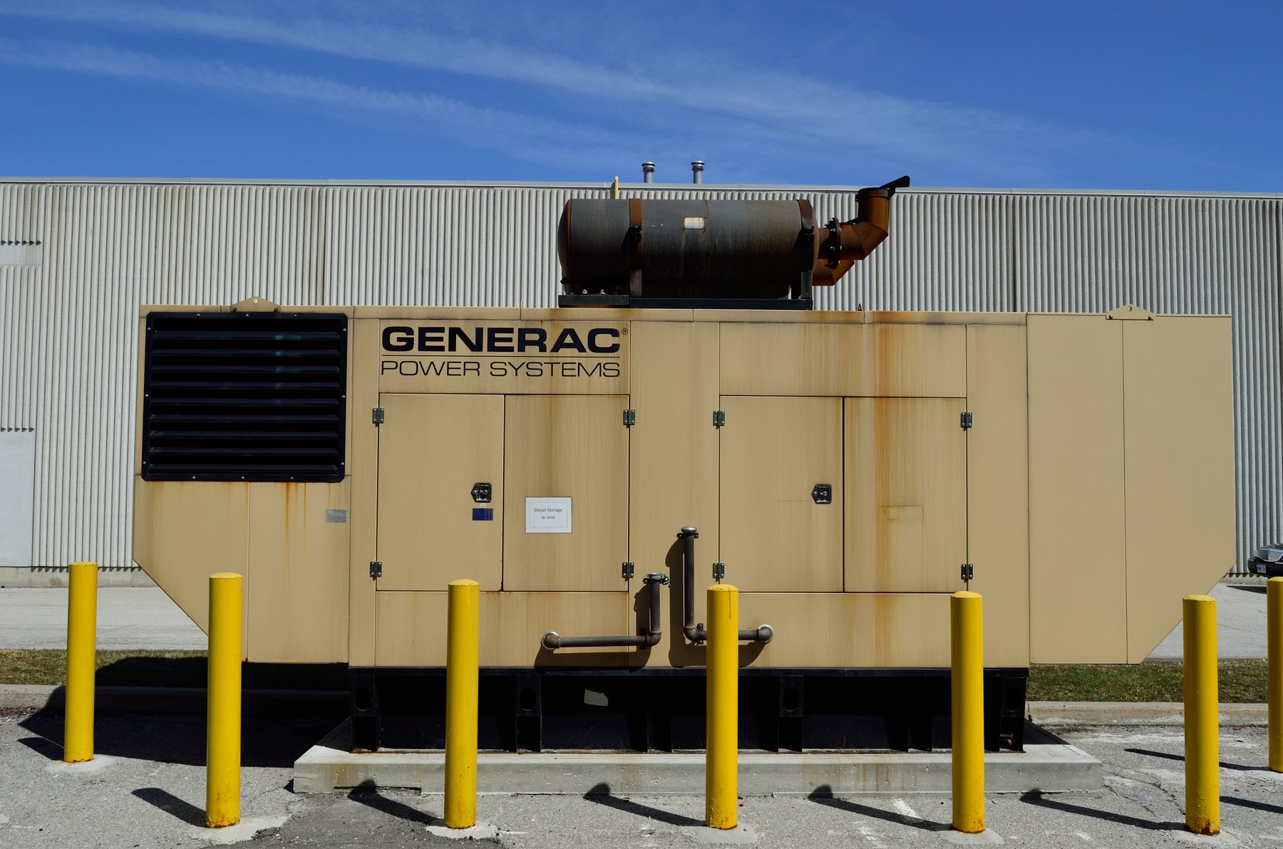 A Generac Power Systems industrial generator outside a commercial building