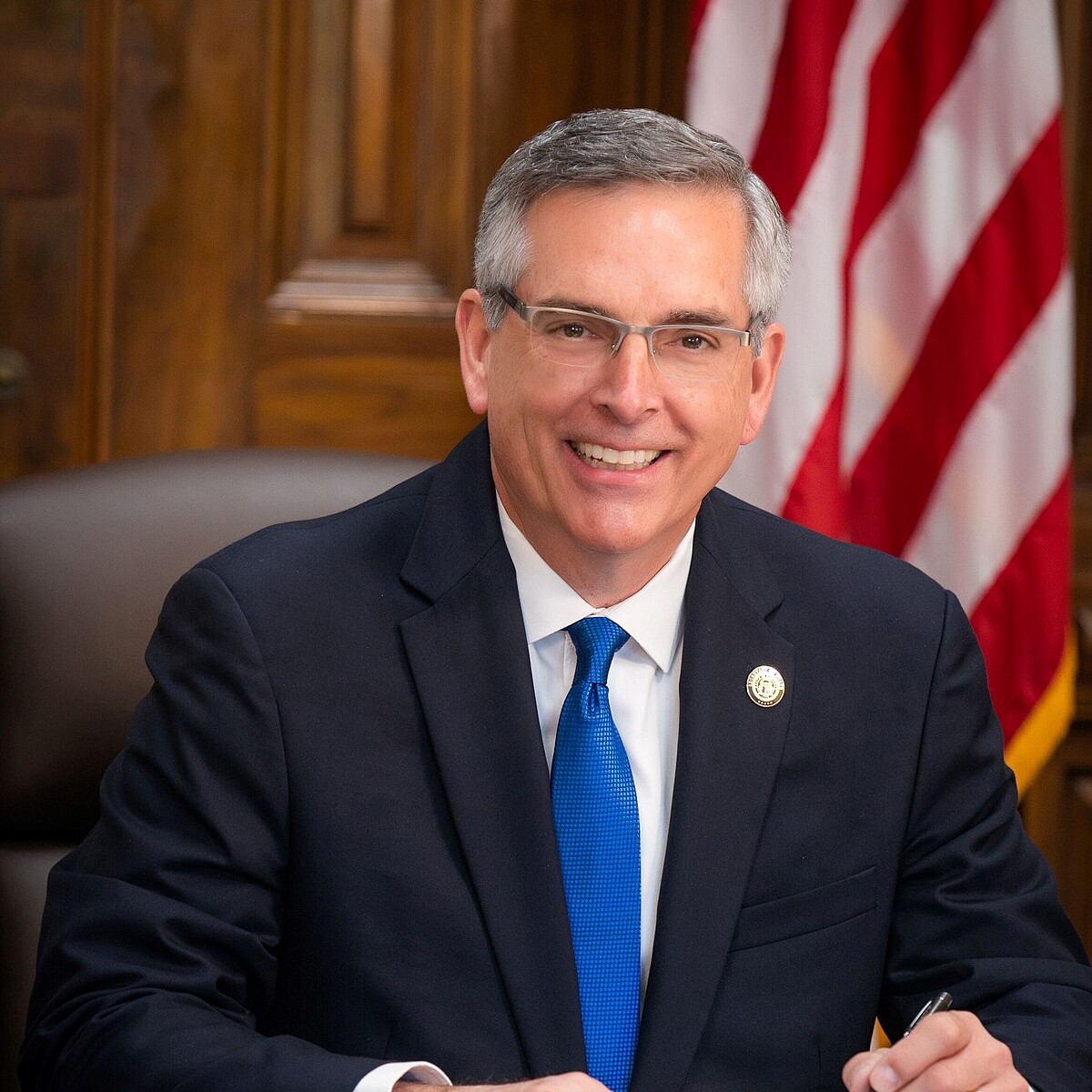Official portrait of Georgia Secretary of State Brad Raffensperger seated at his desk