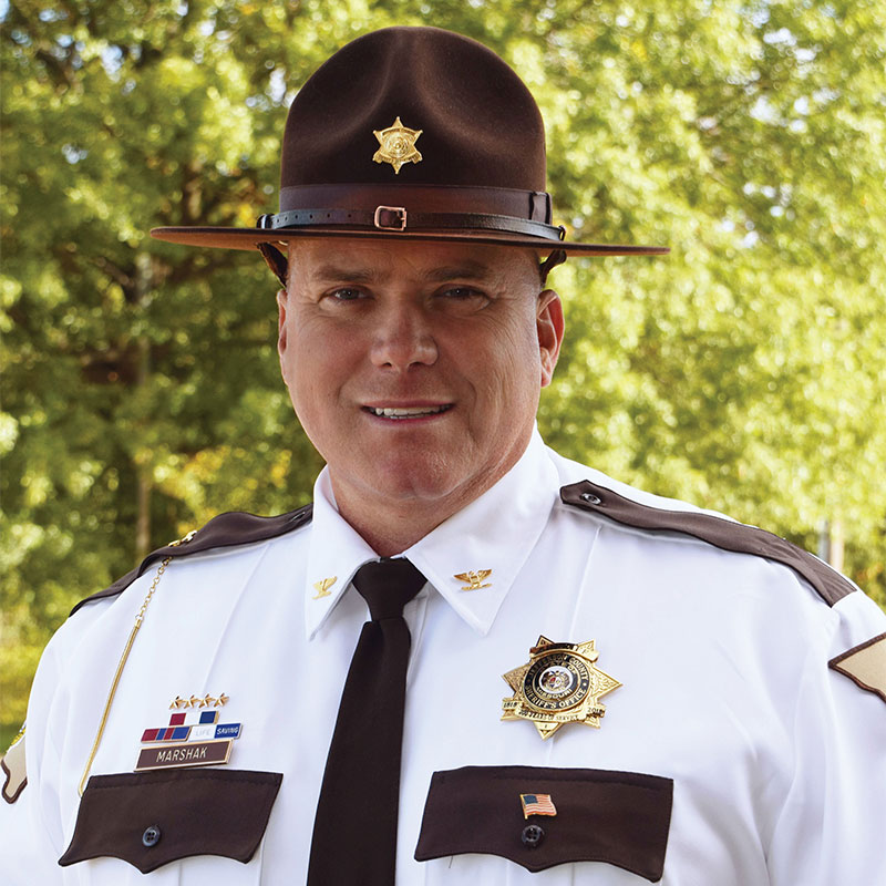 Official portrait of Jefferson County, Missouri Sheriff Dave Marshak in uniform, wearing a campaign hat with a gold star badge and a nameplate reading MARSHAK on his shirt