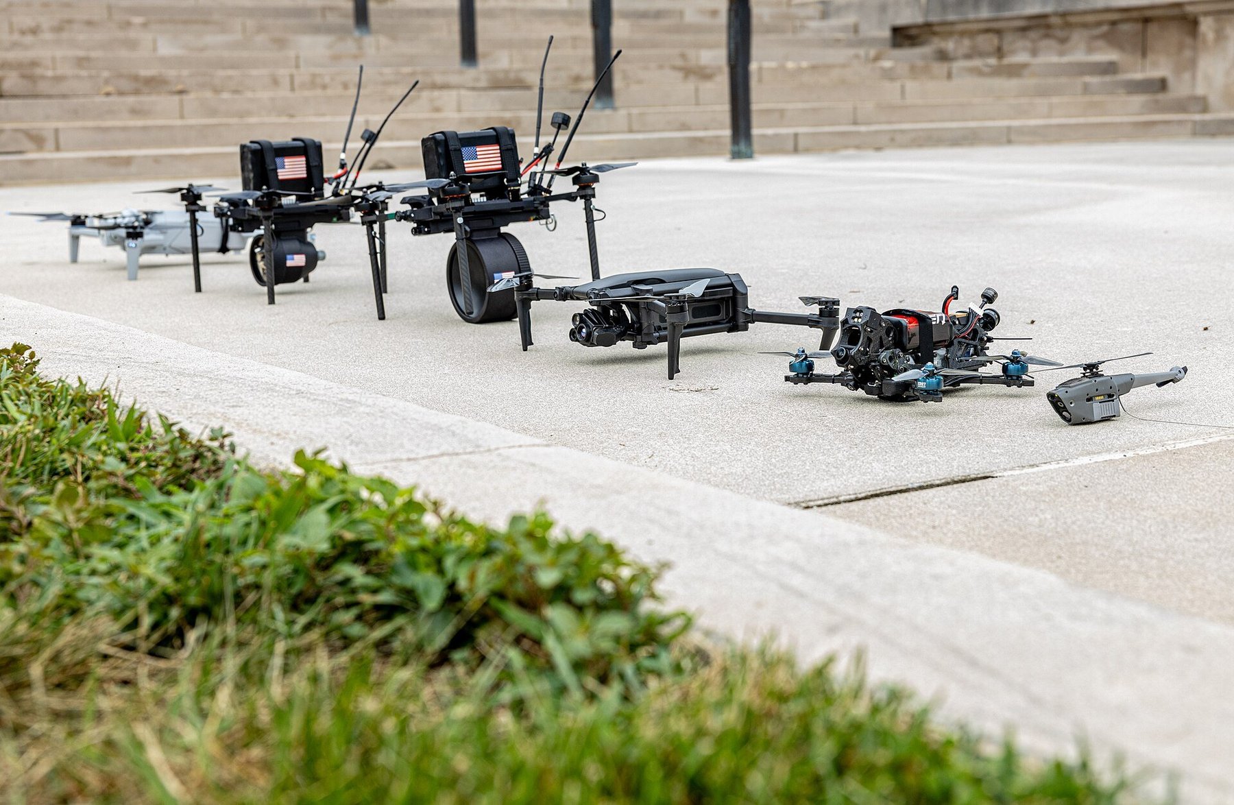 Small unmanned aircraft systems lined up on the pavement outside the Pentagon during a drone demonstration