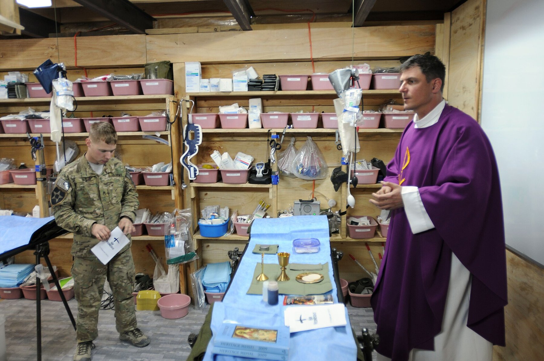 Army chaplain Maj. Paul Madej in purple vestments conducting an Ash Wednesday service for a soldier at a forward operating base in Afghanistan