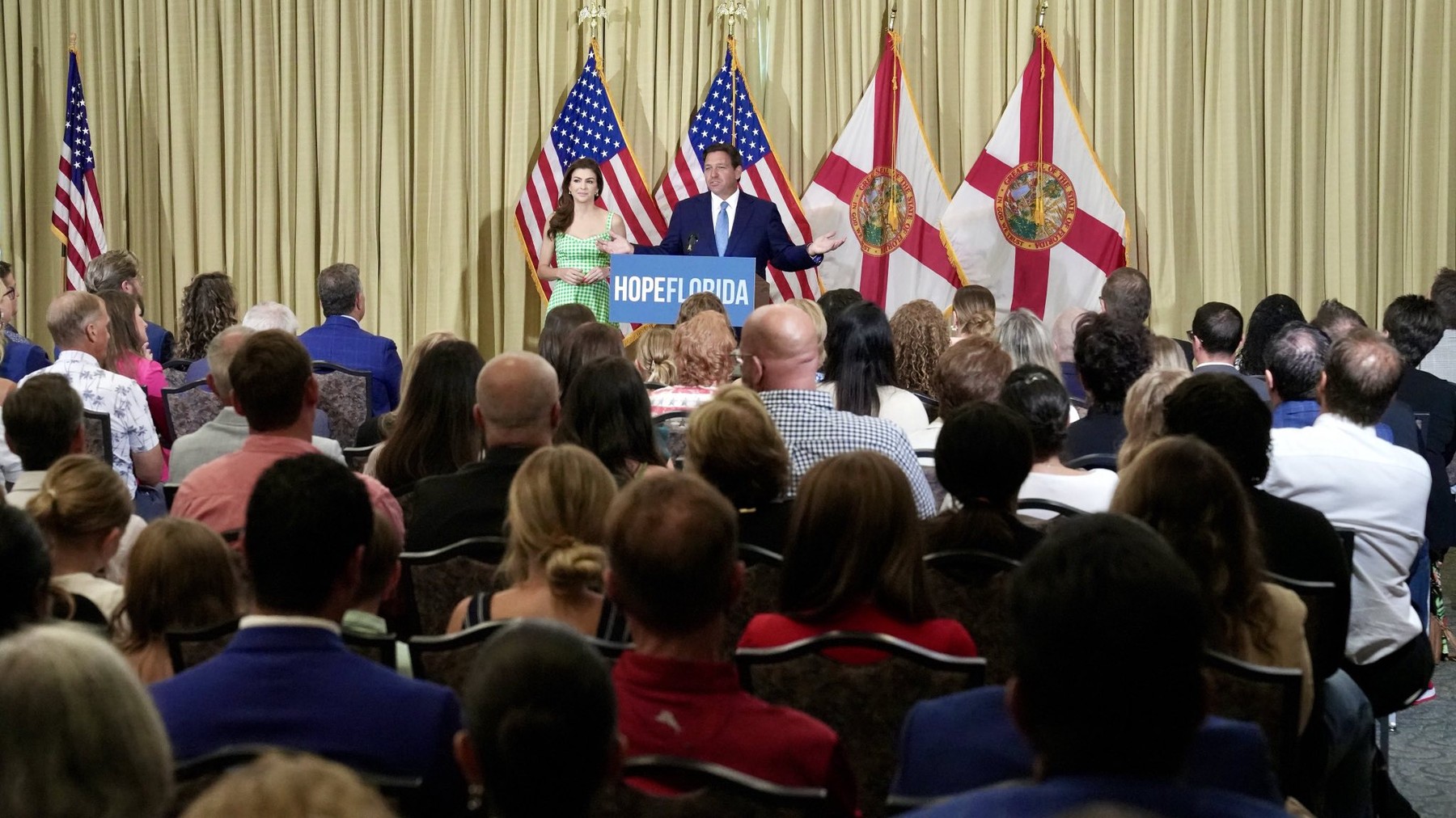 Governor Ron DeSantis and First Lady Casey DeSantis speaking at a Hope Florida conference in July 2024