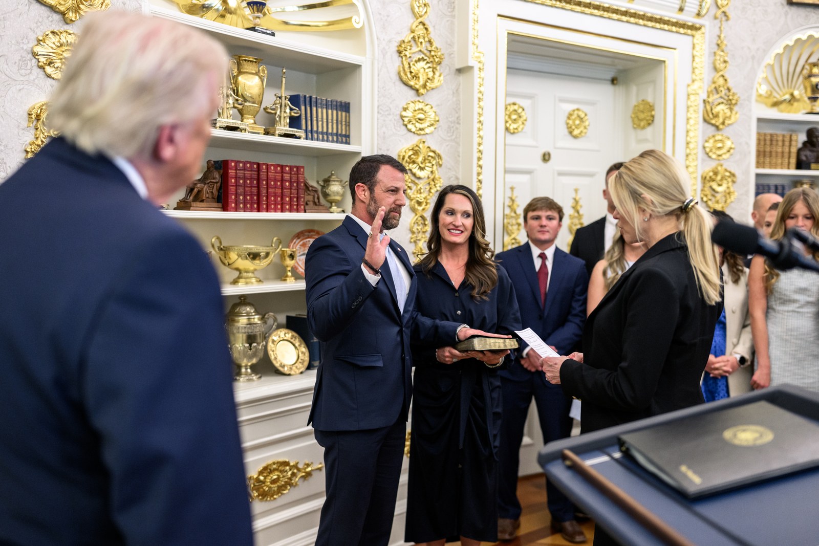 Markwayne Mullin raises his right hand as Attorney General Pam Bondi swears him in as Secretary of Homeland Security, with President Trump watching in the foreground