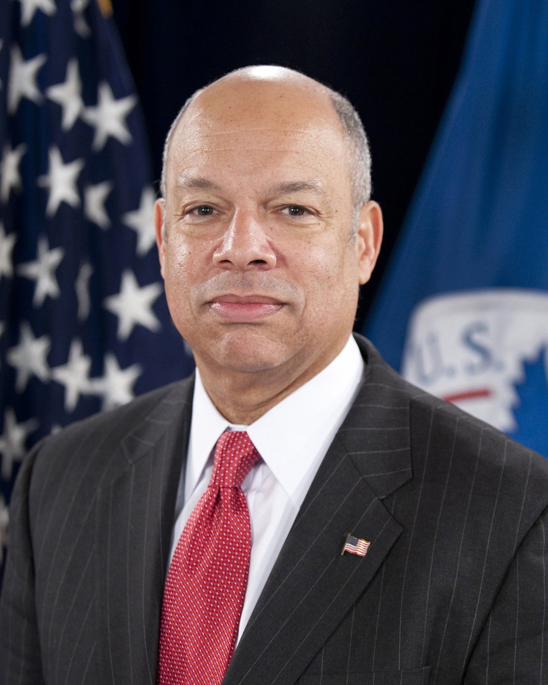 Official Department of Homeland Security portrait of Secretary Jeh Johnson in front of the U.S. and DHS flags