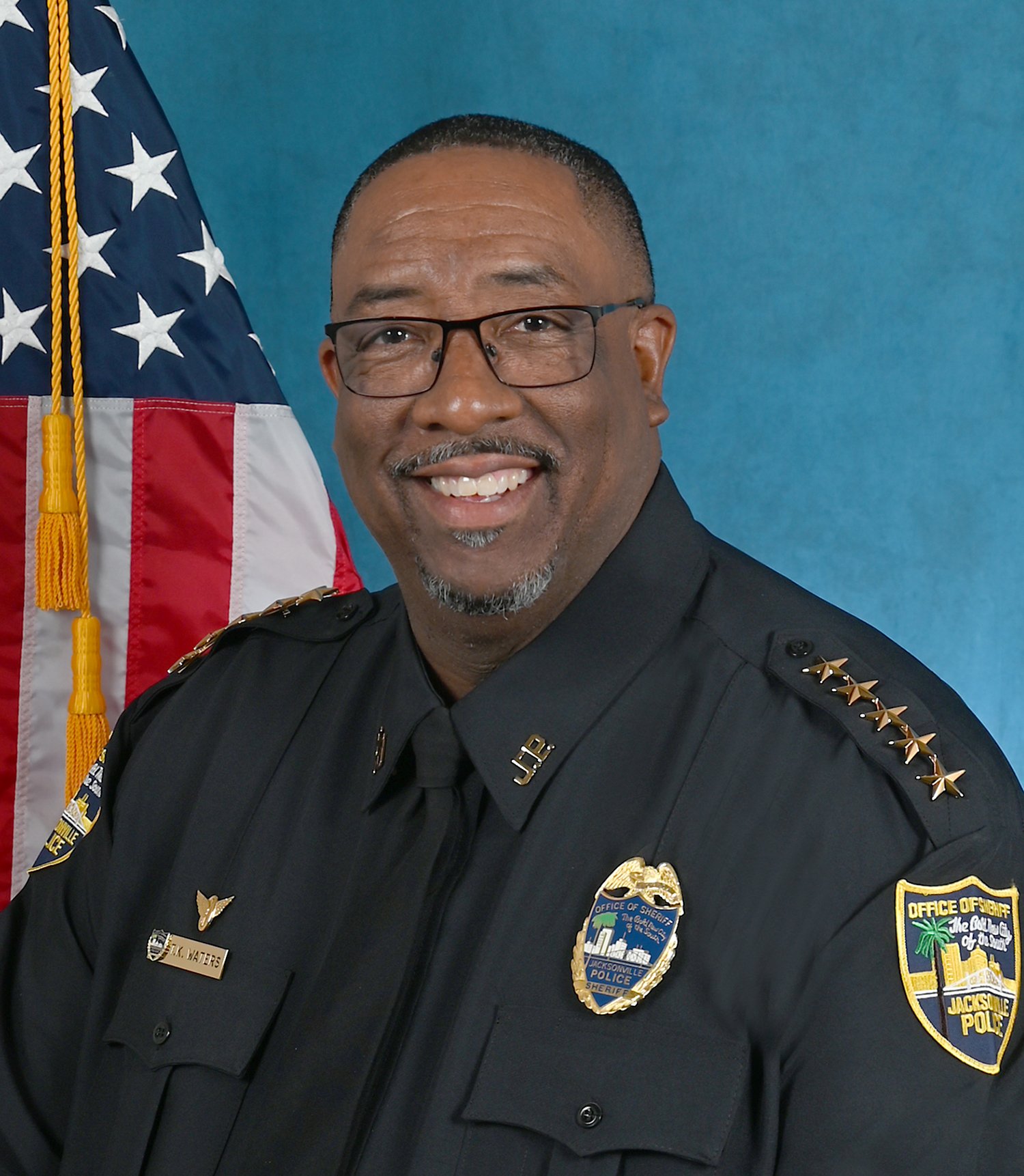Official portrait of Jacksonville Sheriff T.K. Waters in uniform in front of an American flag
