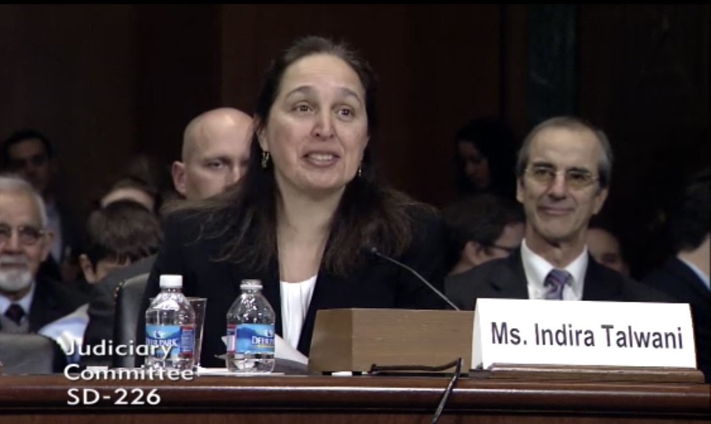 Indira Talwani testifying at her U.S. Senate Judiciary Committee confirmation hearing in 2014, with a nameplate reading Ms. Indira Talwani in front of her