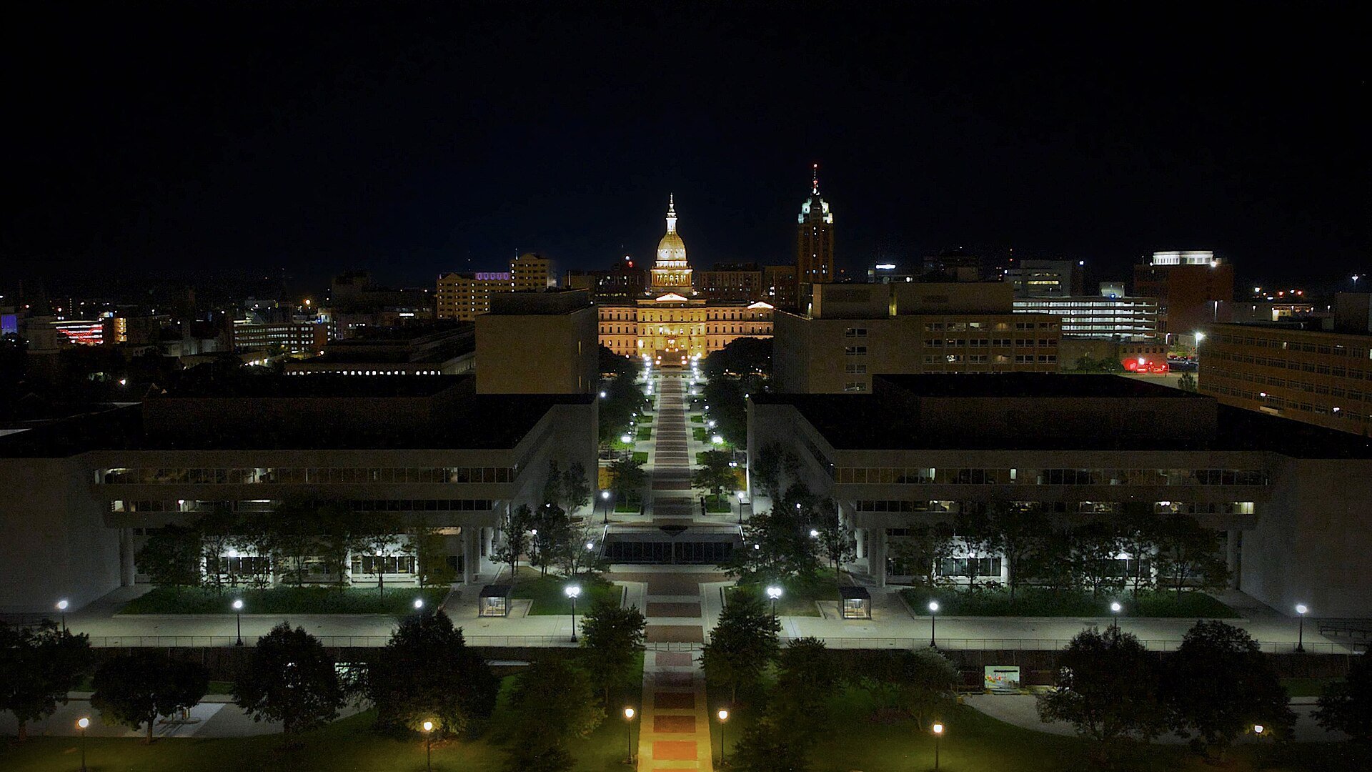 Aerial night view of downtown Lansing, Michigan, looking down the mall toward the lit dome of the Michigan State Capitol