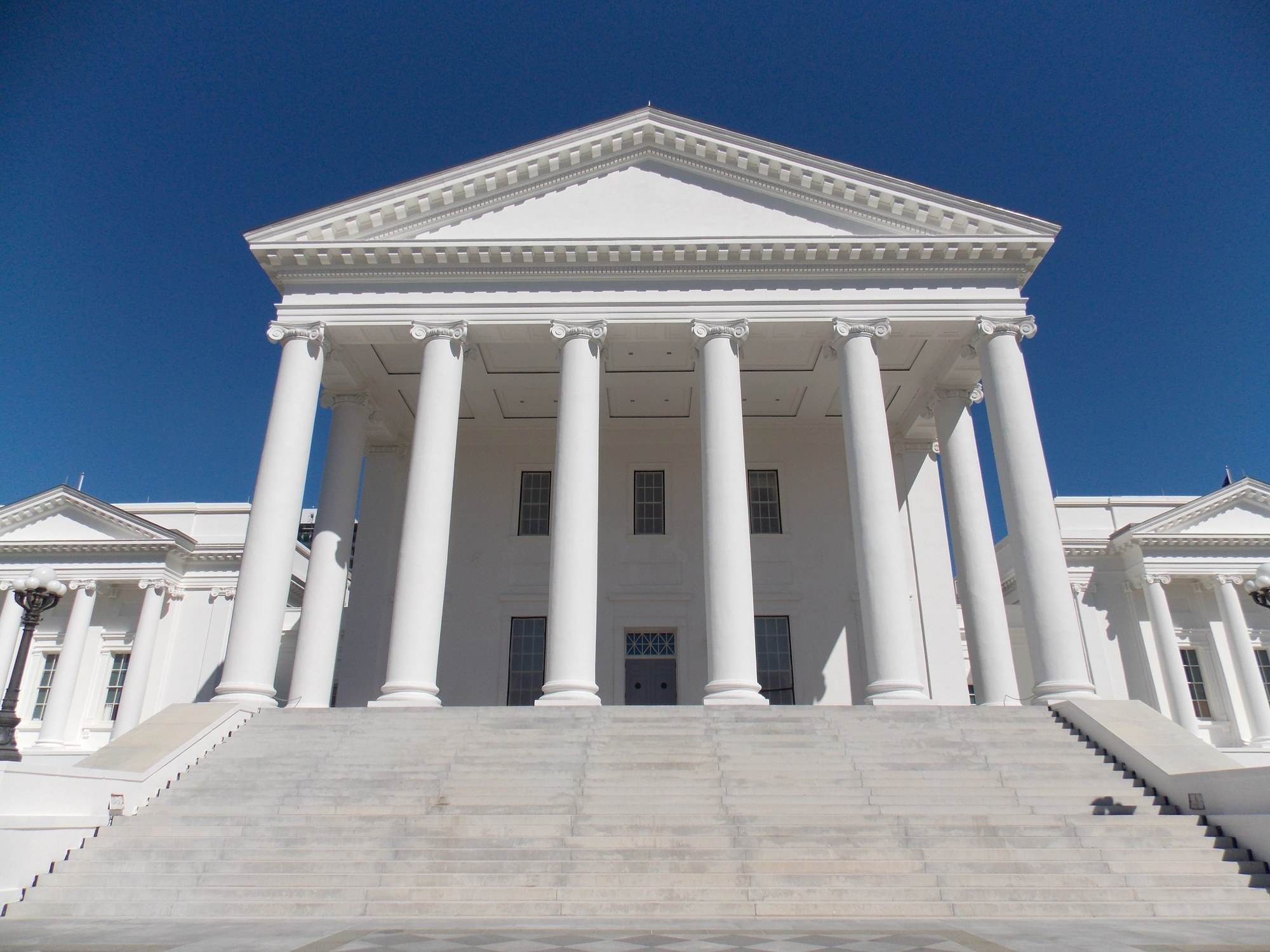 The columned front of the Virginia State Capitol in Richmond under a blue sky