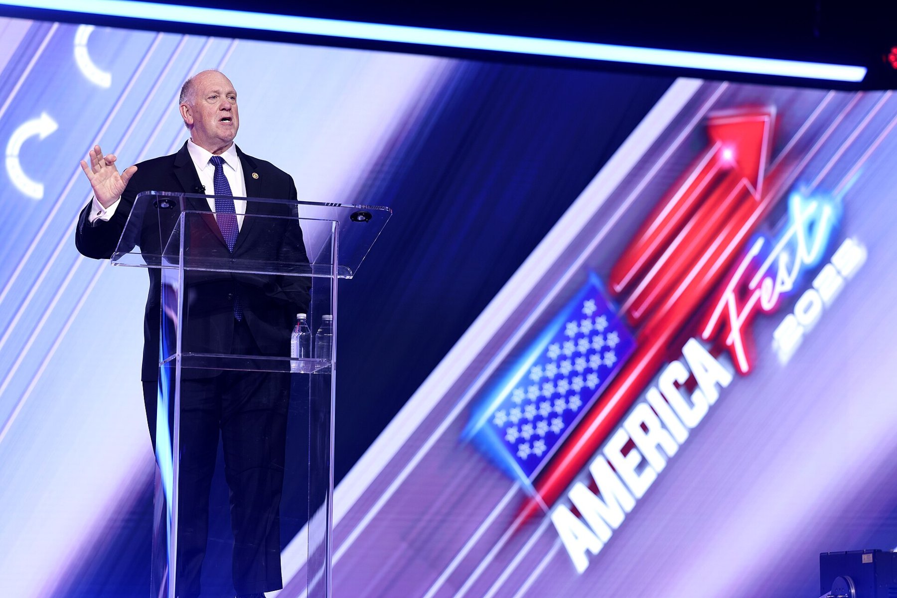 White House border czar Tom Homan speaking at a clear podium at AmericaFest 2025 in Phoenix