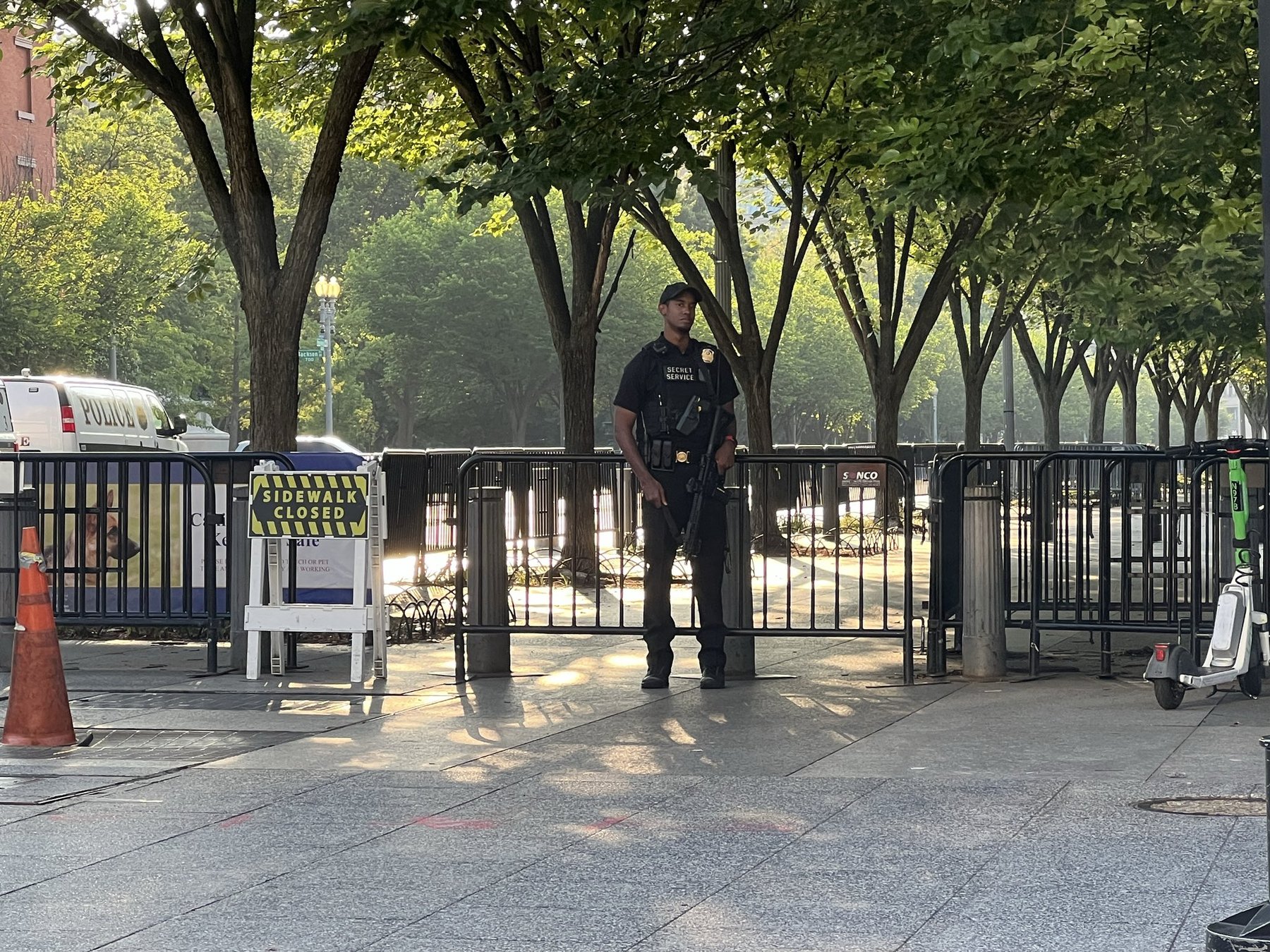 A U.S. Secret Service Uniformed Division officer standing guard on a Washington, D.C. sidewalk behind barricades