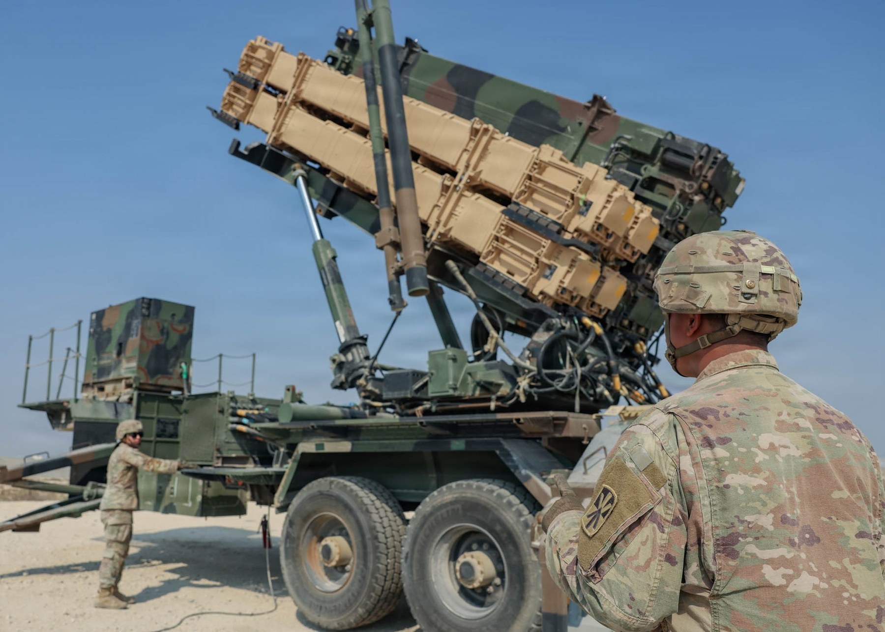 U.S. Army air defense artillerymen work beside an elevated Patriot missile launcher at an undisclosed location in the Middle East