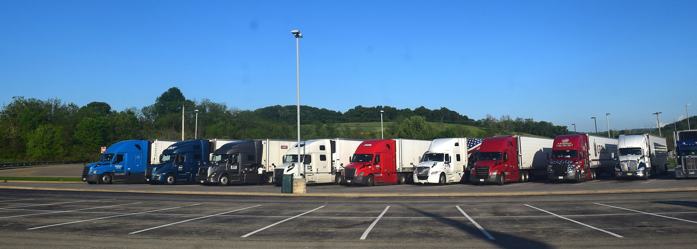Row of tractor-trailers parked at a highway plaza in the United States