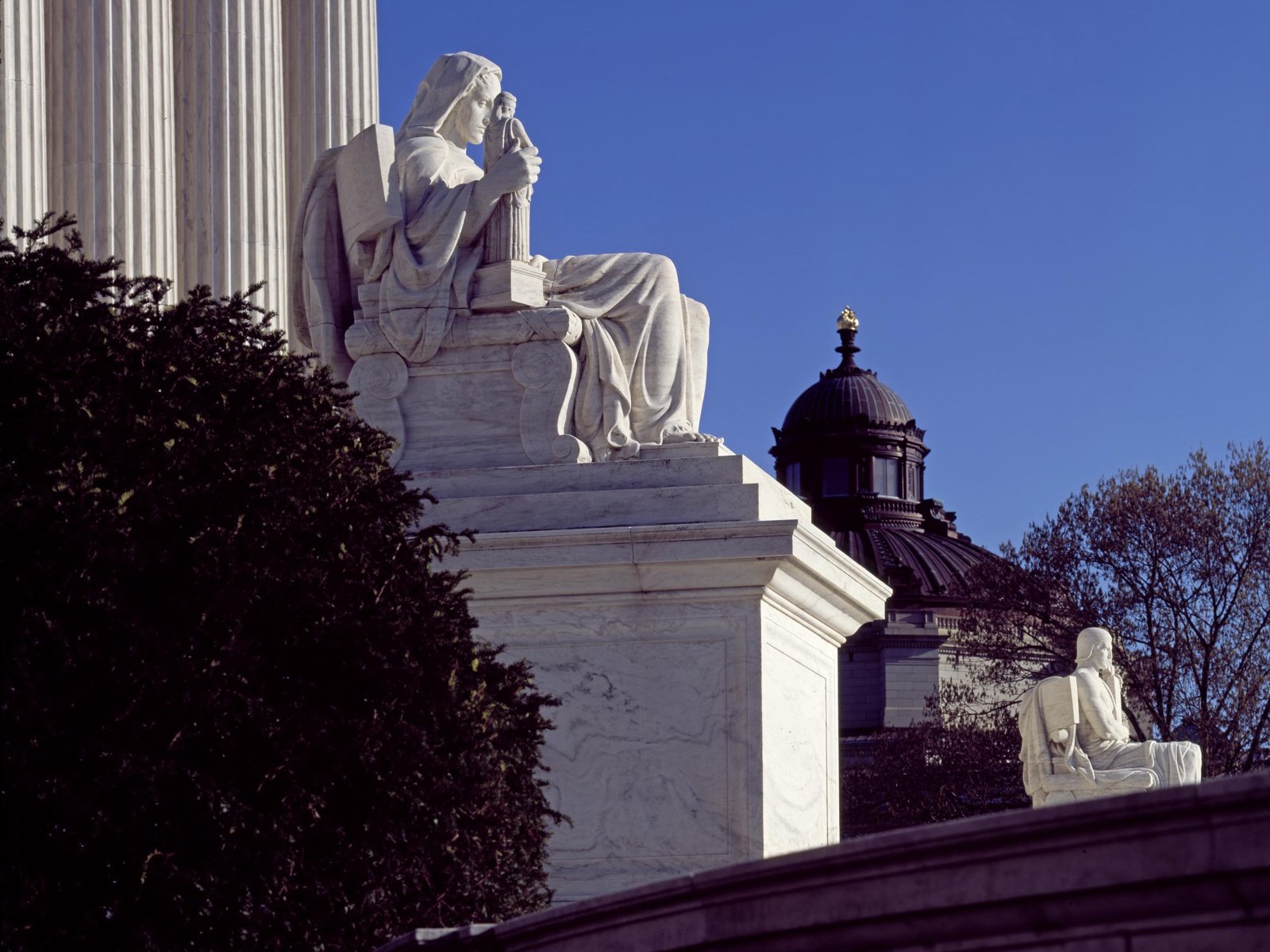 Marble statue Contemplation of Justice beside the columns of the U.S. Supreme Court building