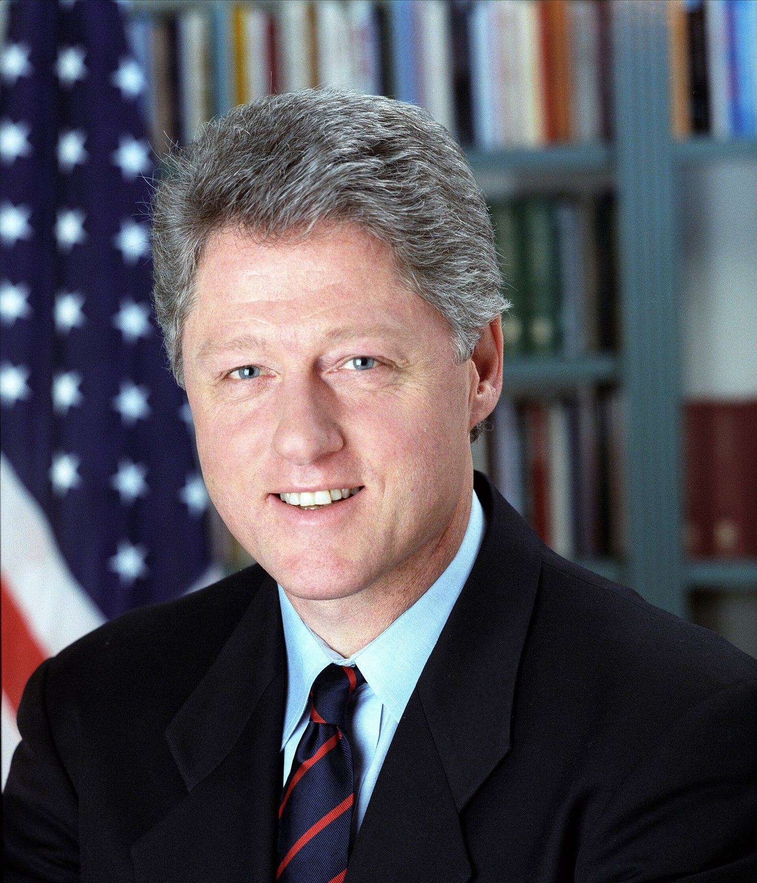 Official White House portrait of President Bill Clinton in front of an American flag and bookshelves