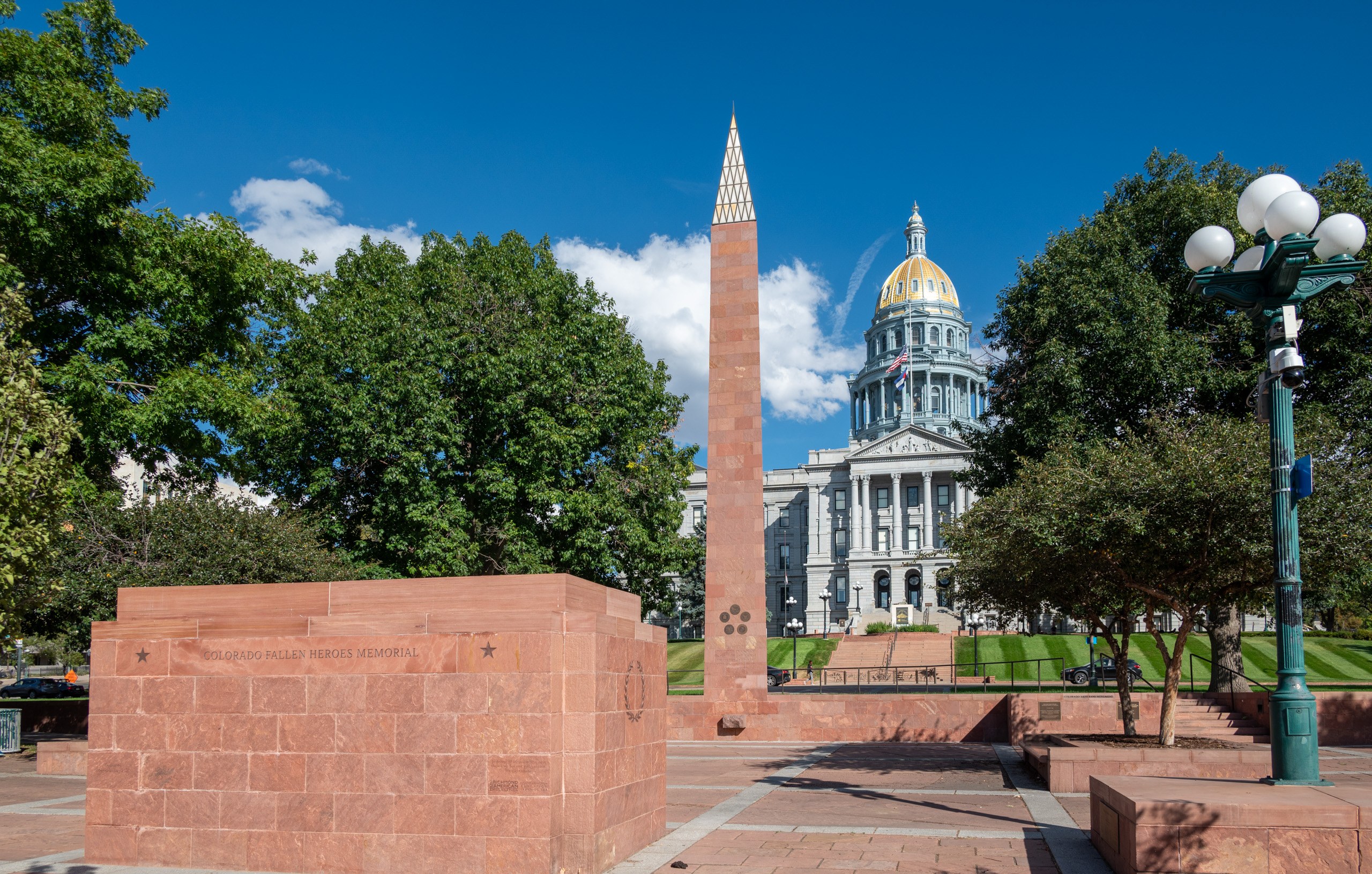 Colorado State Capitol in Denver with its gold dome, seen behind the Colorado Fallen Heroes Memorial