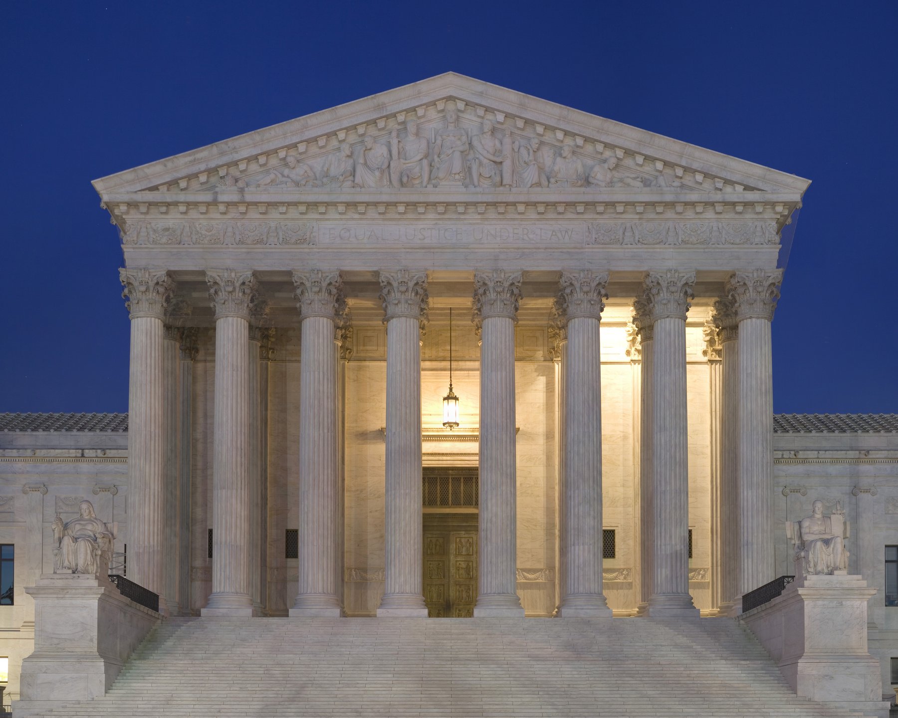 The U.S. Supreme Court building at dusk, lit from within