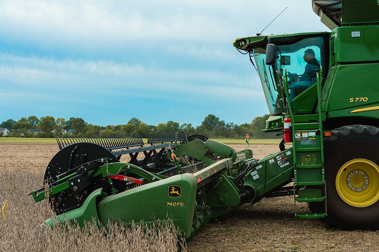 John Deere combine with a soybean header cutting a field in Brownsburg, Indiana