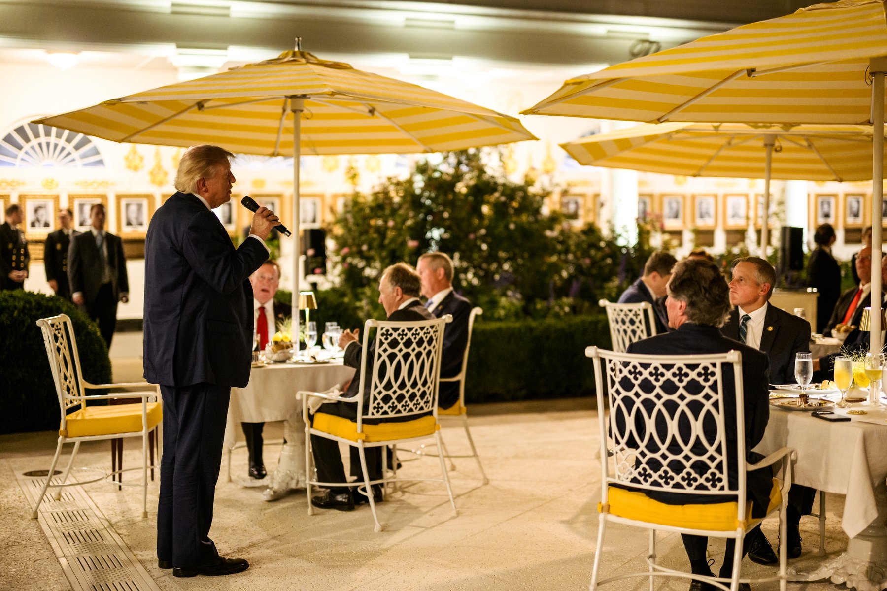 President Donald Trump speaks with a microphone to guests seated under umbrellas at a Rose Garden dinner for hunters and fishermen, September 17, 2026