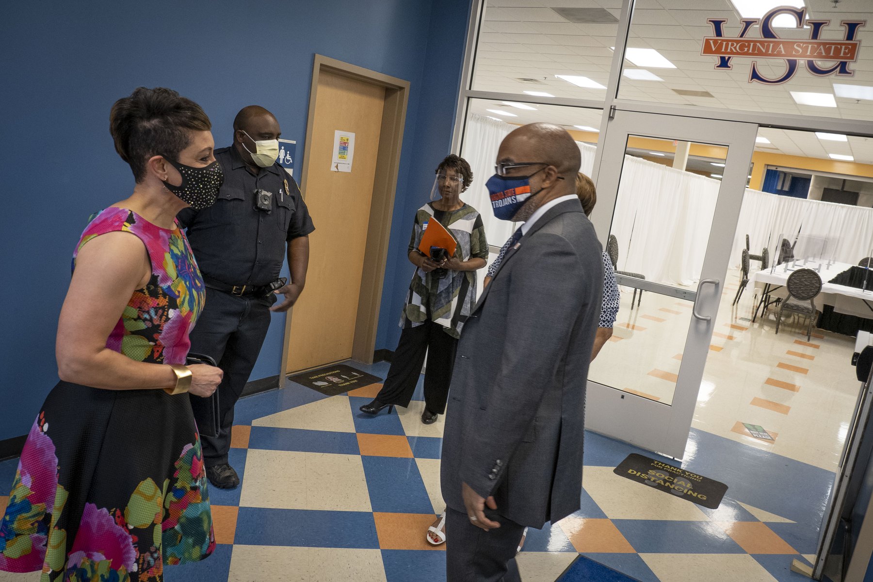 Virginia State University President Dr. Makola M. Abdullah, wearing a VSU face mask, greets a visitor inside a campus building in 2021