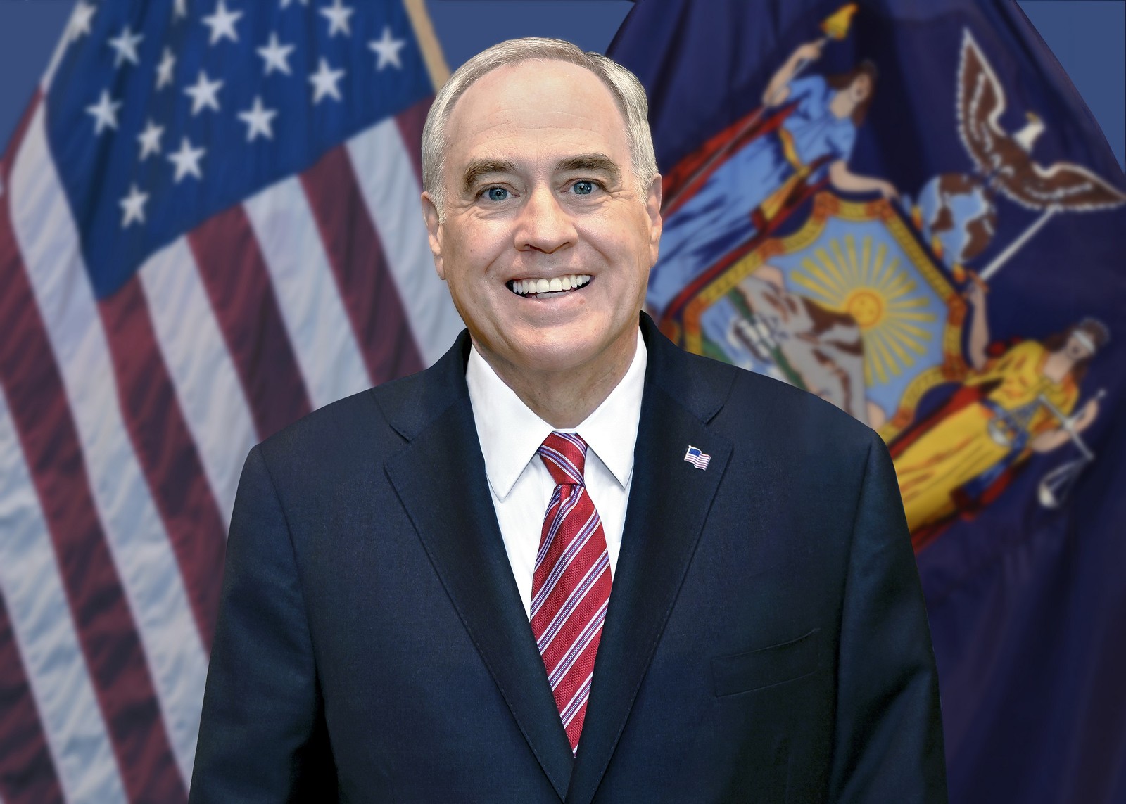 Official headshot of New York State Comptroller Thomas P. DiNapoli in front of United States and New York State flags