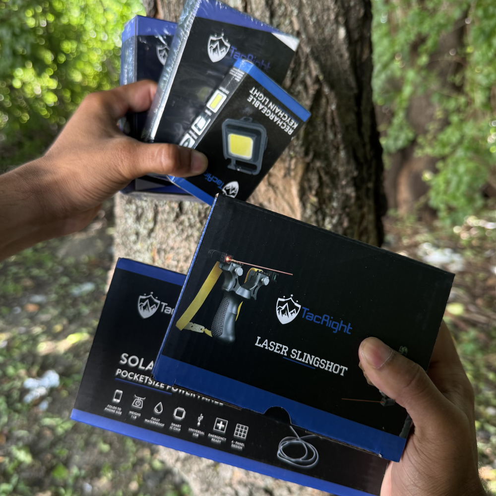 Nic holding gear from his TacticalBox — TacRight laser slingshot, pocket solar power bank and rechargeable keychain light, still boxed