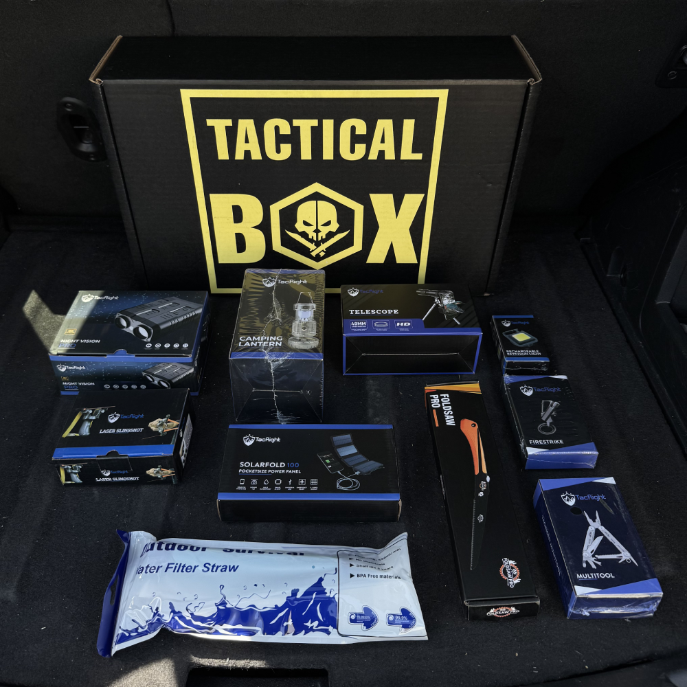 A TacticalBox and its full contents laid out in a truck bed — night vision, laser slingshot, solar panel, multitool, water filter straw