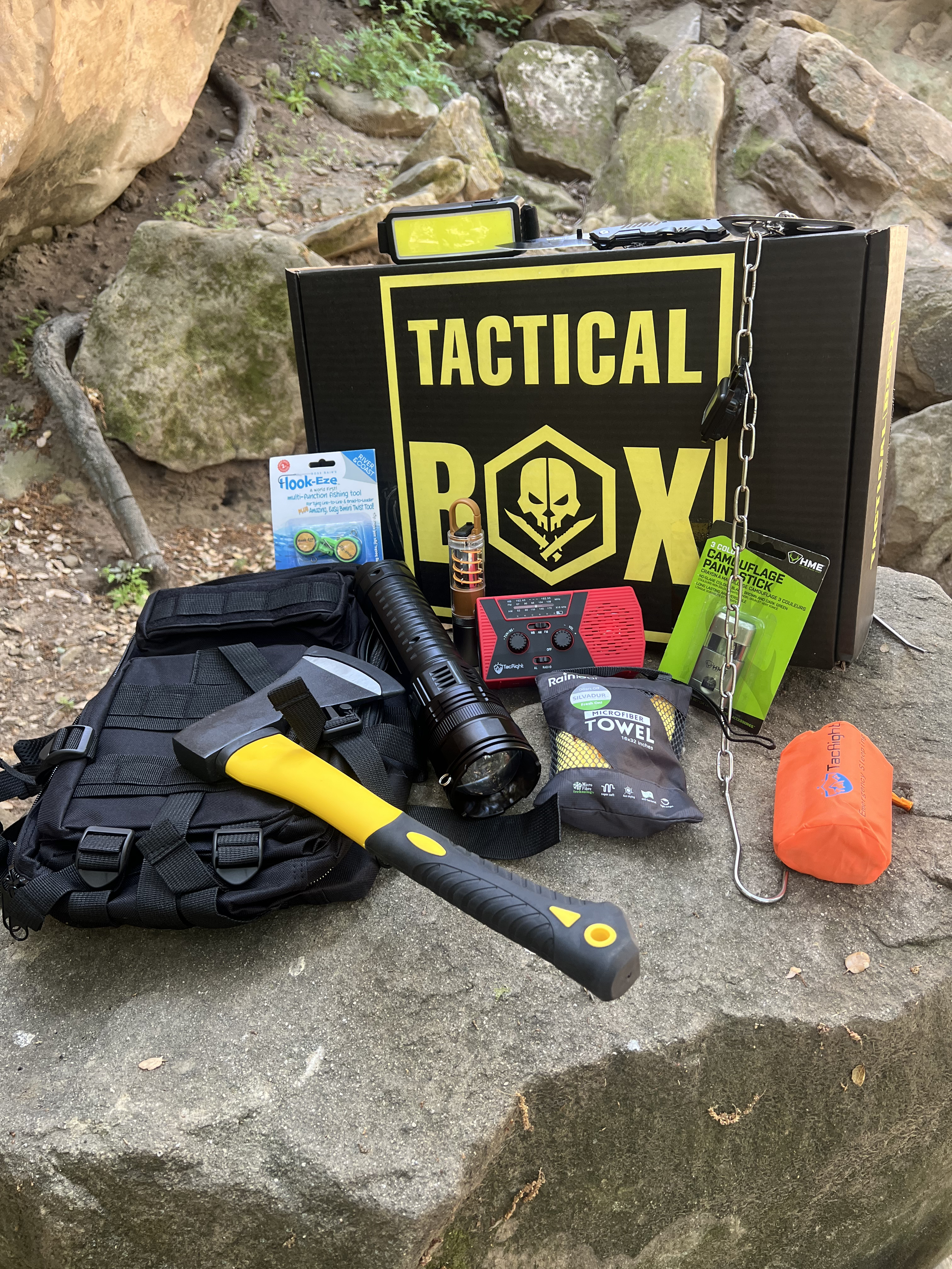 Nic's TacticalBox — open box with gear spread on rocks