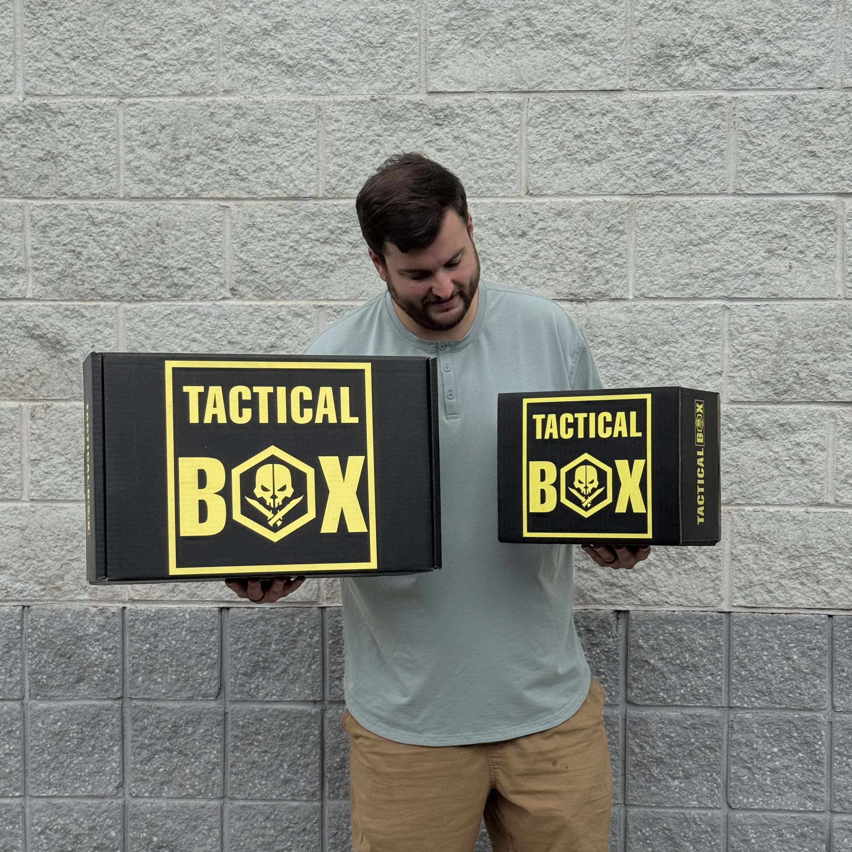 A member holding a small TacticalBox next to a much larger TacticalBox, side by side