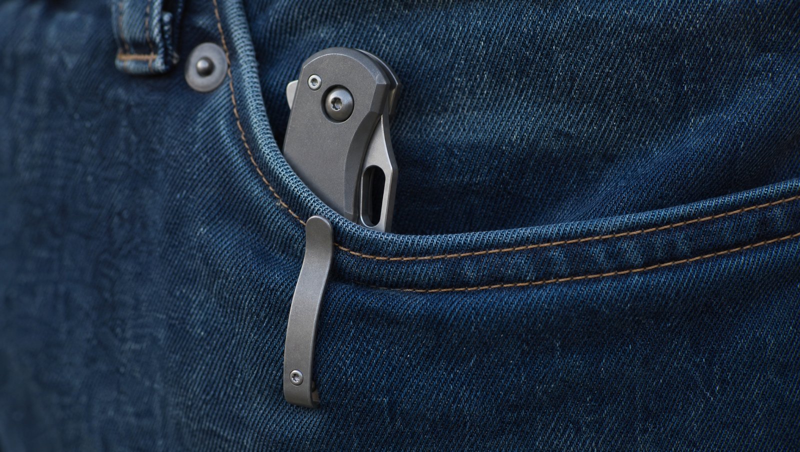 Close-up of a folding pocket knife clipped inside a jeans pocket